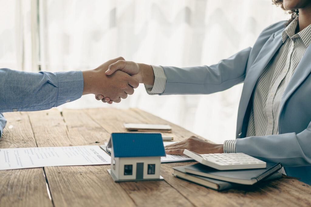 Two people signing a home purchase agreement