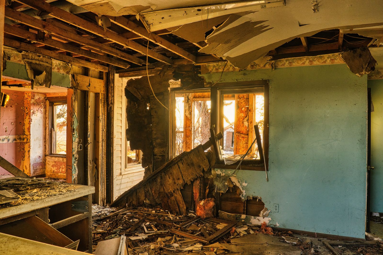 Severely damaged house interior with debris